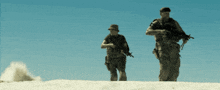 two soldiers walking on a sandy hill with guns