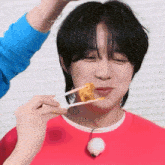 a person is holding a piece of food in front of a person 's face .