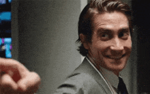 a man in a suit and tie is smiling and looking at someone
