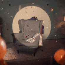 a chair with a blanket on it is surrounded by confetti and balloons