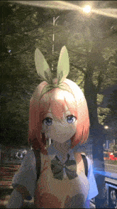 a girl with bunny ears on her head is standing in front of trees