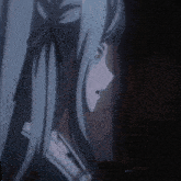 a girl with blue hair is standing in a dark room looking at something .
