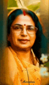 a woman wearing glasses and a yellow shirt has the name meenoos on the bottom left
