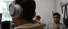 a man wearing headphones is giving a thumbs up sign