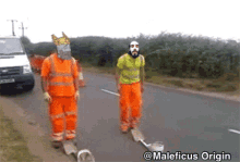 a man wearing a mask and a crown is walking down a road next to another man