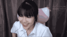 a girl wearing headphones is smiling in front of a screen that says bell jirasan