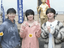 a person wearing a paris sweatshirt stands next to another person