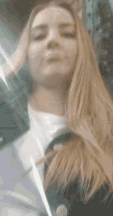 a close up of a woman 's face with long blonde hair looking at the camera .
