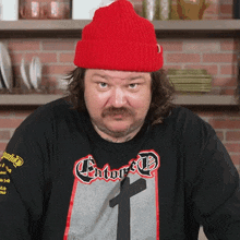 a man wearing a red hat and a t-shirt that says enforced