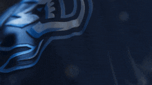 a close up of a blue and black emblem on a dark background