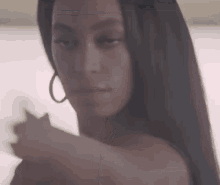 a woman with long hair is standing in front of a window and taking a selfie .