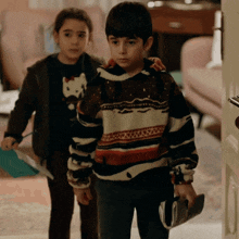 a boy and a girl are standing in a living room