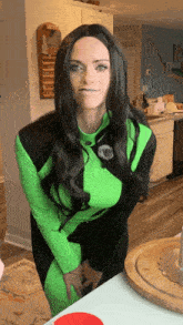 a woman in a green costume is standing in front of a table