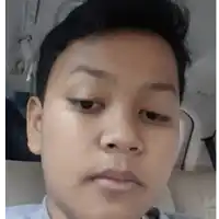 a young boy is sitting in the back seat of a car looking at the camera .