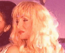 a close up of a woman with blonde hair and red lipstick