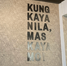 a sign on a wall says kung kaya nila mas kaya moi