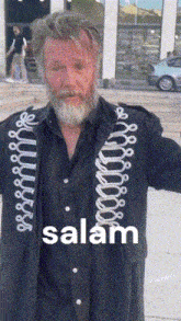 a man with a beard is wearing a black jacket that says salam on it