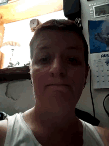 a woman sitting in front of a calendar that says august on it