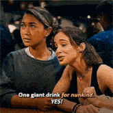 two women are sitting at a table and one of them is saying `` one giant drink for nunkind . ``