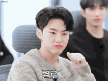 a young man making a funny face with korean writing on his face