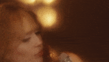 a close up of a woman 's face with a blurry background of lights .