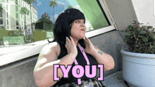 a woman wearing a lanyard that says [ you ]