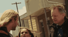 a man and a woman are standing in front of a building and talking to each other
