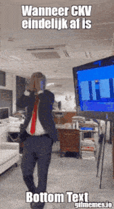 a man in a suit and red tie is dancing in front of a television with the caption bottom text