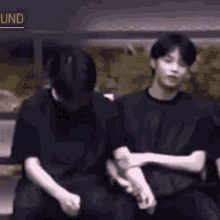 a group of young men are sitting next to each other and hugging .
