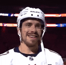a hockey player wearing a white helmet that says bauer on it