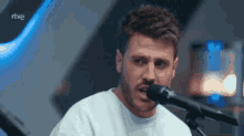 a man singing into a microphone with the word rtve on the bottom