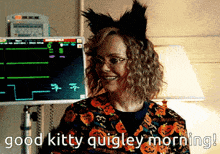 a woman wearing a cat ear headband says good kitty quigley morning .