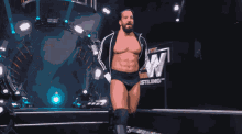 a wrestler stands in front of a sign that says aew