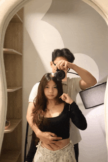 a man taking a picture of a woman in a mirror