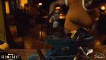 a person grinding a piece of metal with a disney logo in the corner
