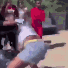 a group of people are standing around a man in a red dress .