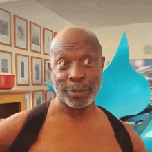 a bald man with a beard is wearing a black strap around his neck