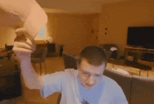 a man is sitting on a couch in a living room holding a piece of paper in his hand .