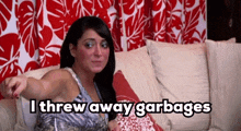 a woman is sitting on a couch with the words " i threw away garbages " below her