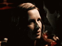 a close up of a woman 's face with a key in her mouth .
