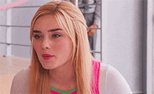 a close up of a woman 's face with blonde hair and pink lipstick .