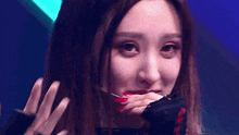 a close up of a woman with red nails making a face .
