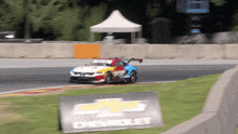 a chevrolet sign is in front of a race car on the track