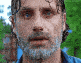 a man with a beard and blue eyes is looking at the camera with a surprised look on his face .