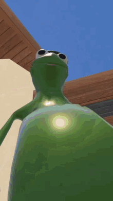 a green frog standing in front of a house