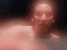 a close up of a woman 's face in a bathtub with a red light behind her