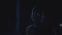a man and a woman are standing next to each other in the dark .