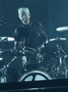 a man wearing a hat with the letter o on it playing drums