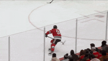 a hockey player is being lifted in the air by a crowd of people .