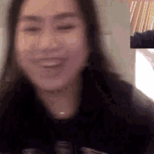 a woman is smiling while talking on a video call with a man .